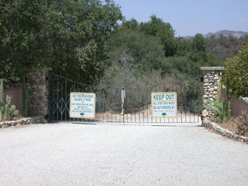 The main gate to the Ranch, with two large signs warning away uninvited visitors.